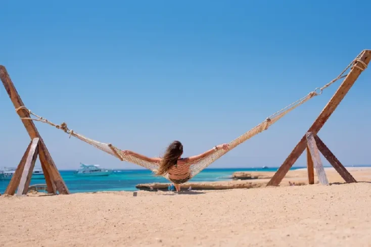 una donna rilassa alla spiaggia egiziana sul mare rosso, egitto dove andare al mare