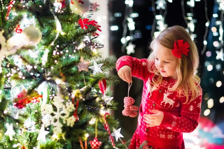 Dove andare a Natale, una ragazza accanto al albero di Natale