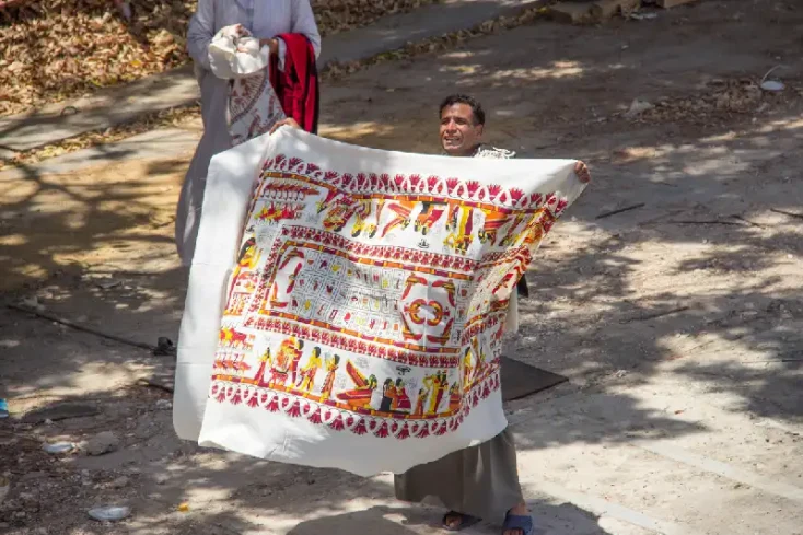 un uomo vende un tappeto souvenir ad Esna , Esna