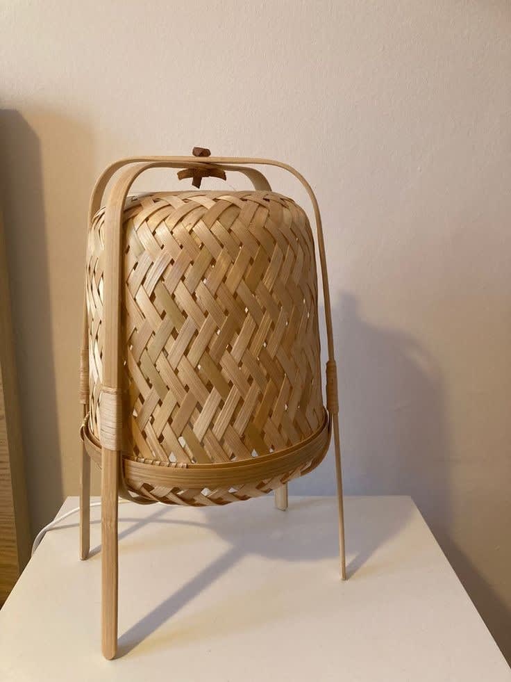 Handwoven Bamboo Table Lamp — on a bedside table with warm ambient light