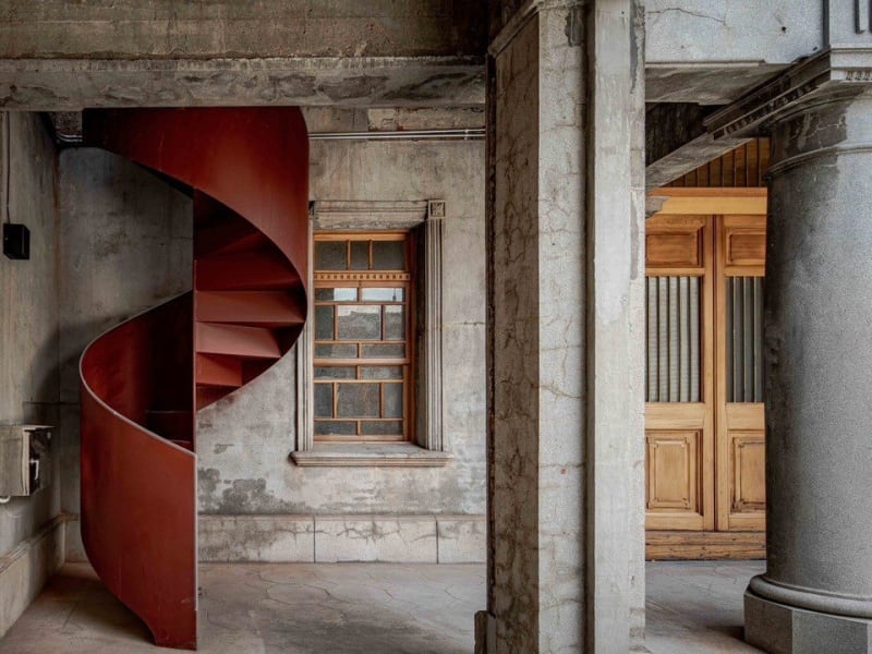A red spiral staircase, a modern insertion into the mansion's century-old stonework ©Fang Zhai