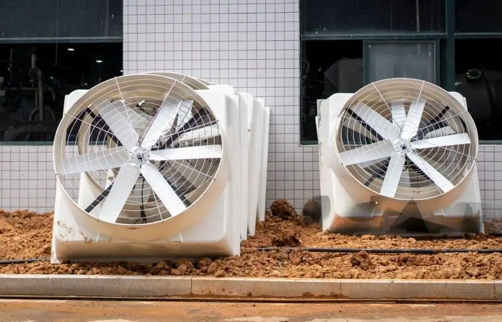 Large industrial exhaust fans installed outside a tiled building wall