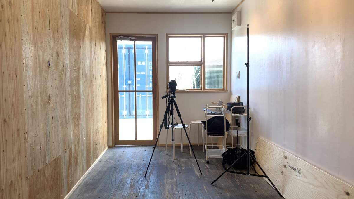 2023年2月の店内。壁は合板が貼られただけで、三脚とカメラ、パイプ椅子しか置かれていない