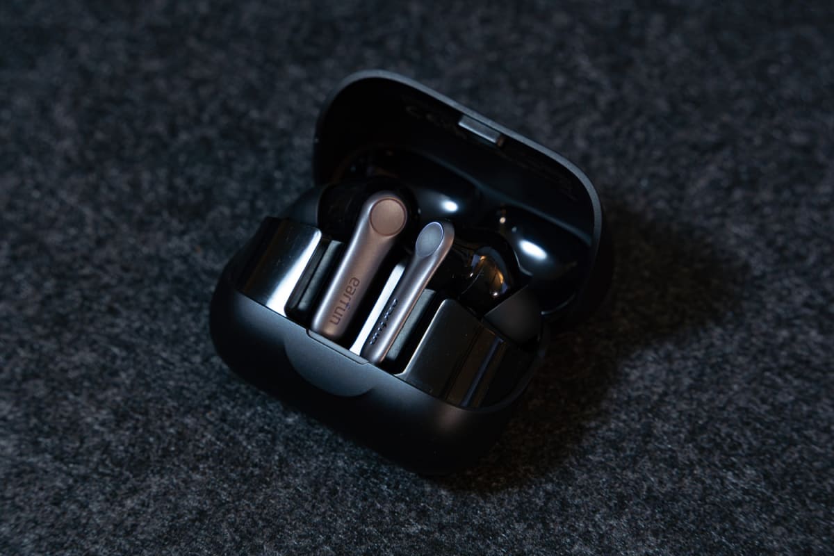 ケースを開けた状態のEarFun Air Pro 4+。黒い充電ケースの中に、シルバーの軸を持つイヤホンが2つ収まっている