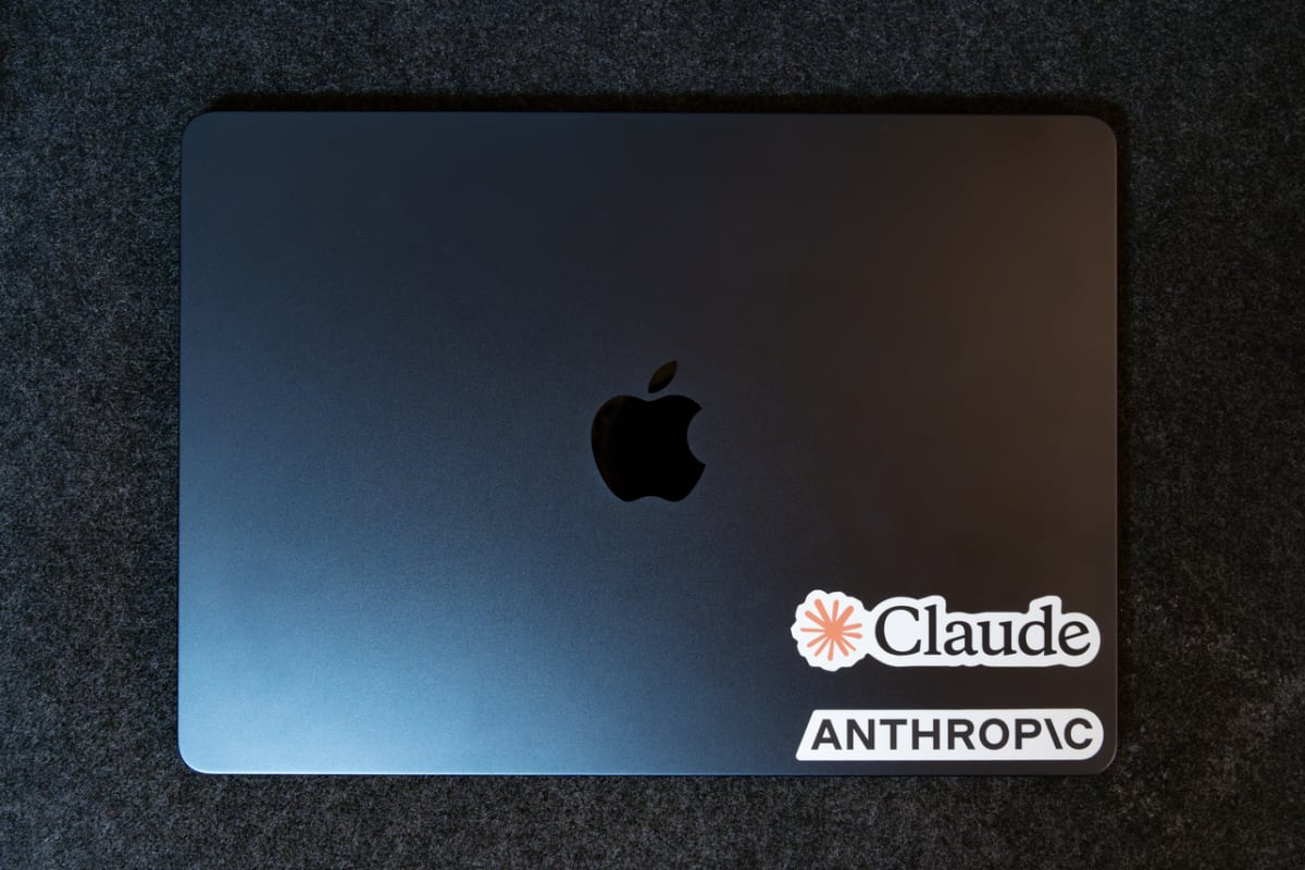 閉じた状態のMacBook Airの天板。ミッドナイト色で、右下にClaudeとAnthropicのステッカーが貼られている