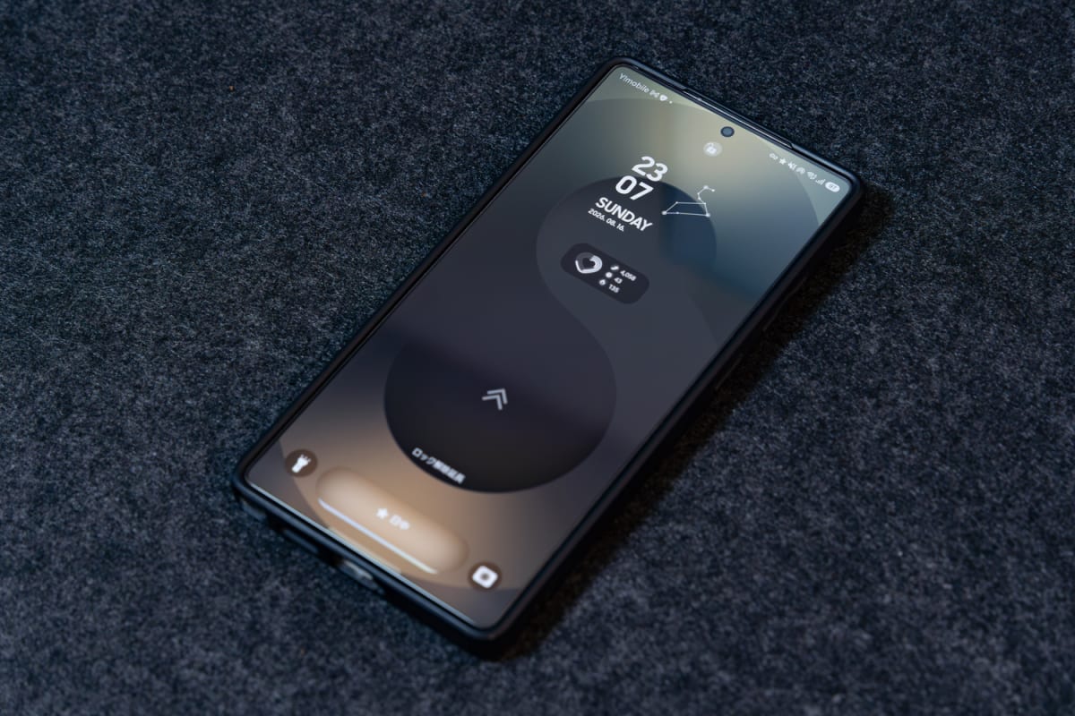 濃い灰色の布の上に置かれたGalaxy S25 Ultra。ロック画面に時刻と日付が表示されている