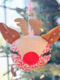 Woollypetals Reindeer Ornament with red nose and brown antlers hanging on tree
