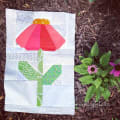 Woollypetals Echinacea Quilt Block with red petals, green leaves, and gold center