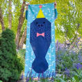 Woollypetals Manatee Migration Quilt wall hanging with blue manatee and yellow hat