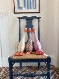 Woollypetals Silly Goose stuffed geese displayed on a navy blue chair