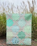 Woollypetals Floored quilt displayed outdoors with tall ornamental grasses