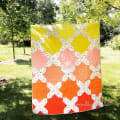 Woollypetals Floored quilt displaying rainbow color gradient from yellow to red