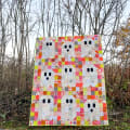 Woollypetals Ghost Party quilt with colorful patchwork squares displayed outdoors