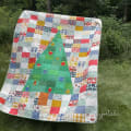 Woollypetals Oh Christmas Tree quilt with patchwork border and green tree appliqué