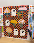 Woollypetals Capped quilt with orange, black, and cream checkered patchwork and ghost appliqués