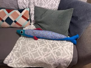 Woollypetals Sardine Pillow in blue with colorful polka dot fabric on couch