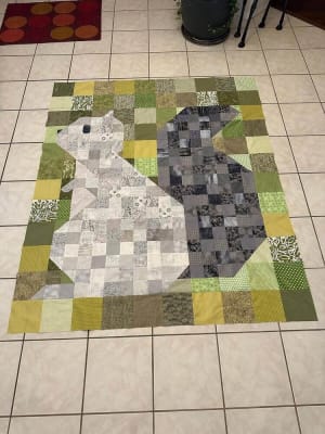 Woollypetals Squirrel quilt with green, yellow, and gray patchwork blocks