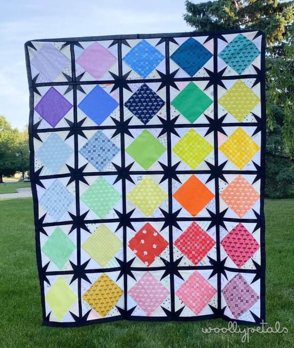 Woollypetals Sparked Quilt in rainbow diamond blocks with black star sashing