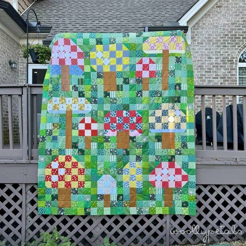 Woollypetals Capped quilt featuring patchwork mushroom blocks on a brick patio