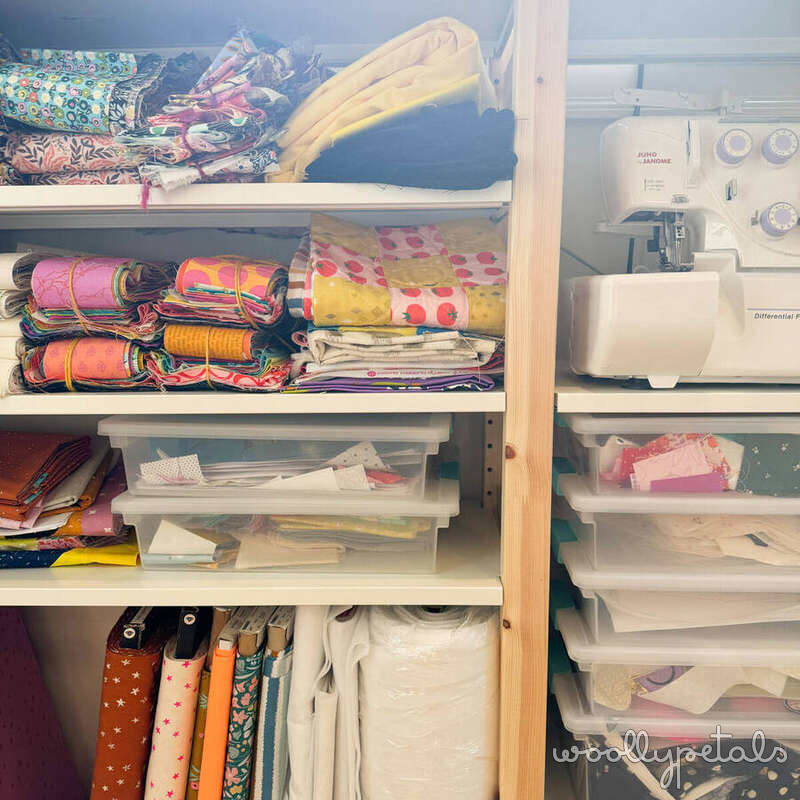 Organized sewing room shelving with fabric, thread, and sewing supplies