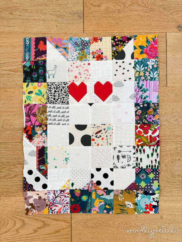 Woollypetals Ghost Party quilt with colorful fabric border and white center blocks