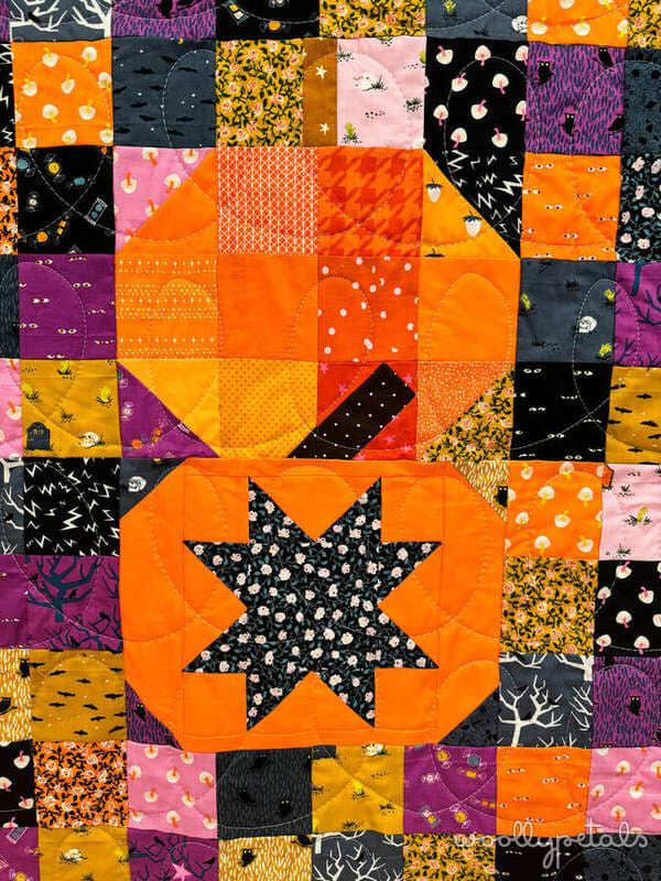 Woollypetals Ghost Party Pumpkins quilt with orange pumpkin star center and colorful patchwork blocks