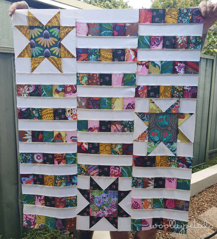 Woollypetals StarBeam quilt in colorful patchwork fabrics with sawtooth stars
