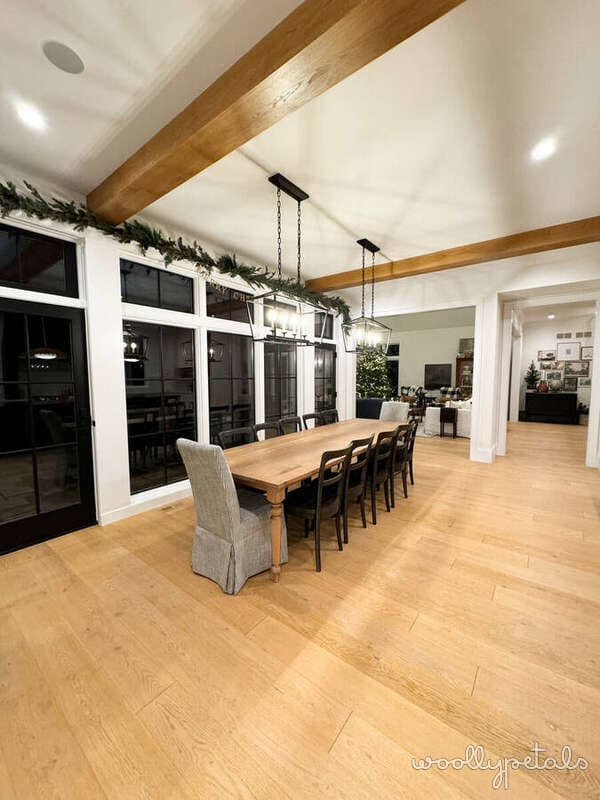 Modern dining room with wooden table, black chairs, and exposed beams