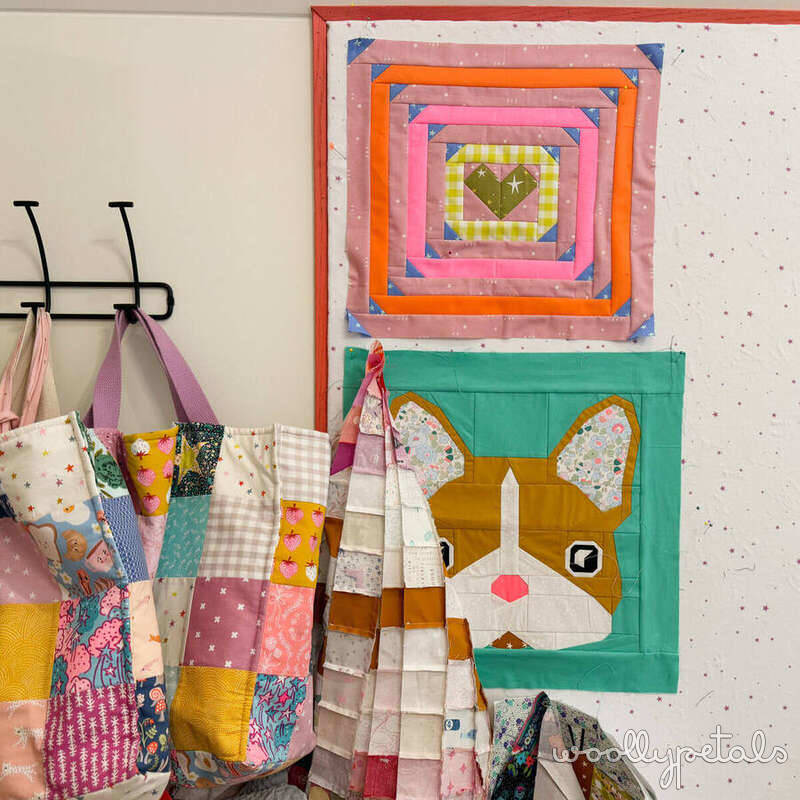 Sewing room wall with colorful quilted design boards and fabric storage