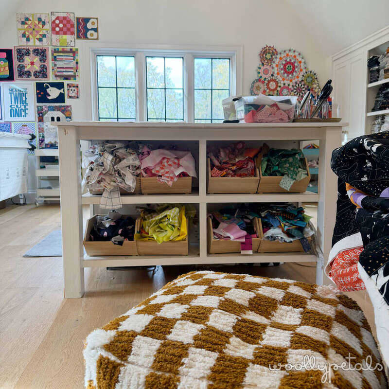 Sewing room with fabric storage shelving and checkered rug