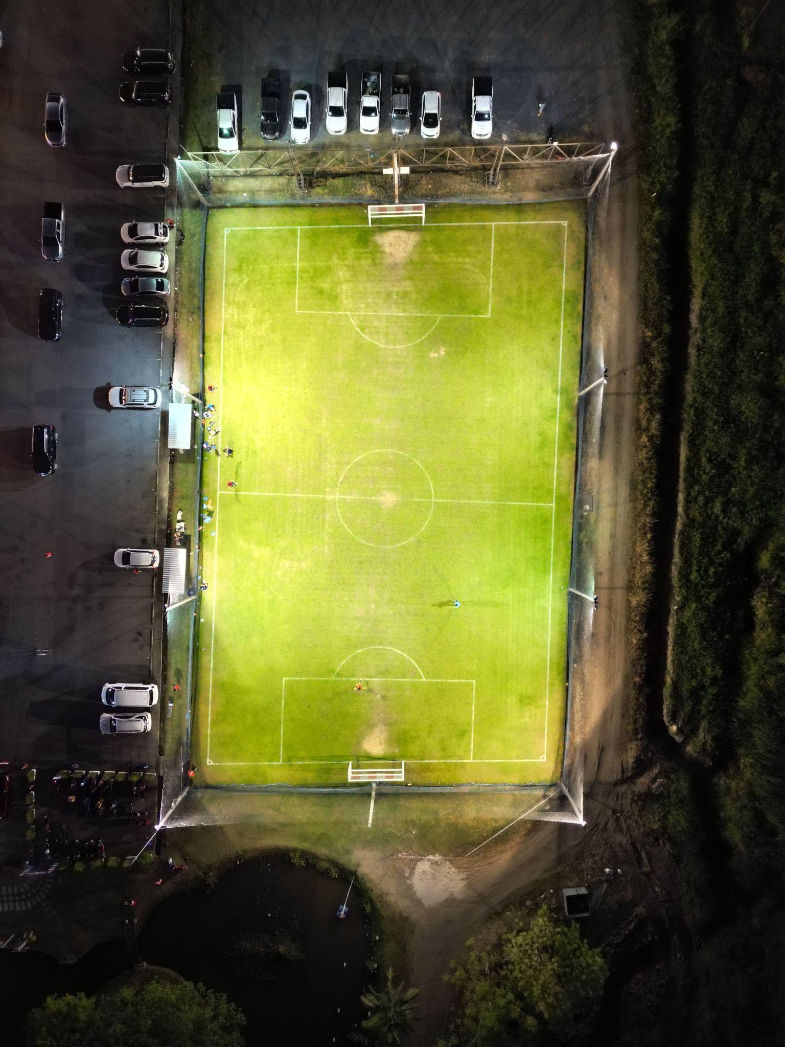 Vista aérea de quadra de futebol society noturna