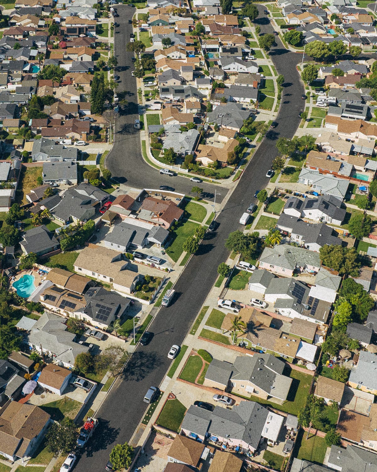 An aerial view down a suburban street lined with homes