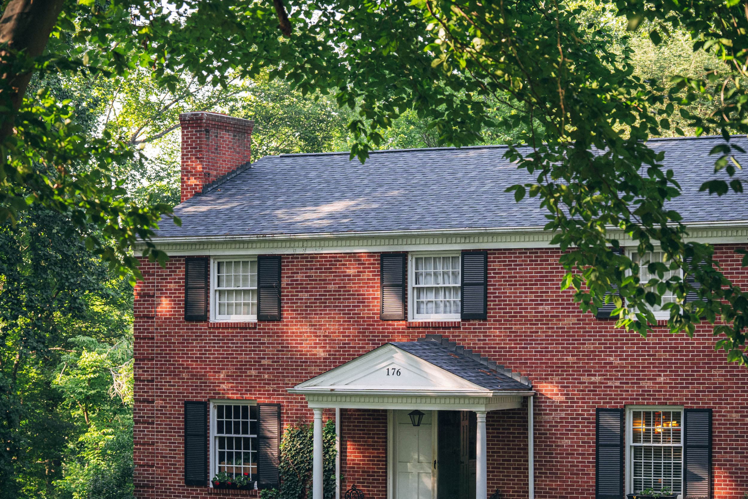 A red-brick colonial home with a new shingle roof