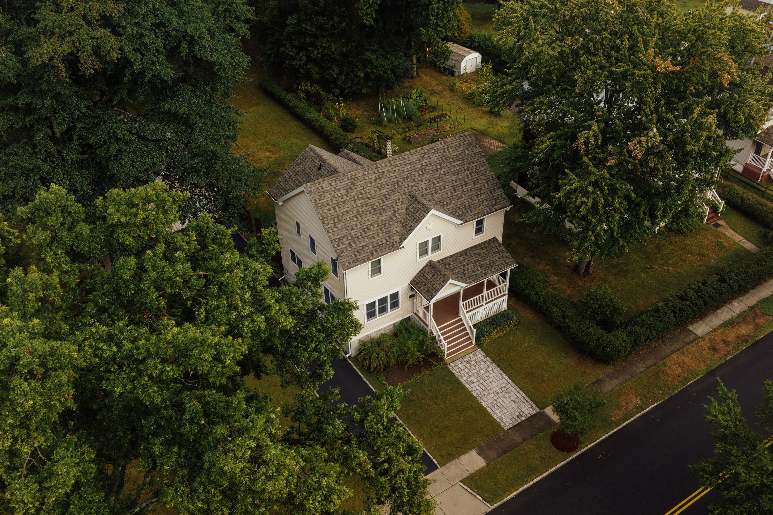An aerial view of a white two-story home and its front walk
