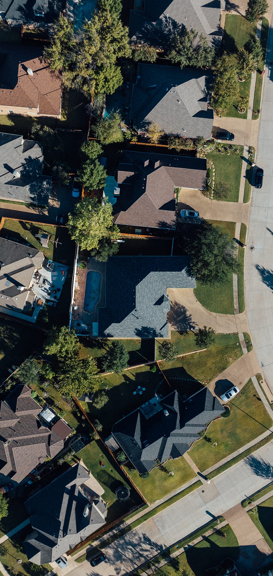 An overhead view of a suburban street of freshly shingled homes