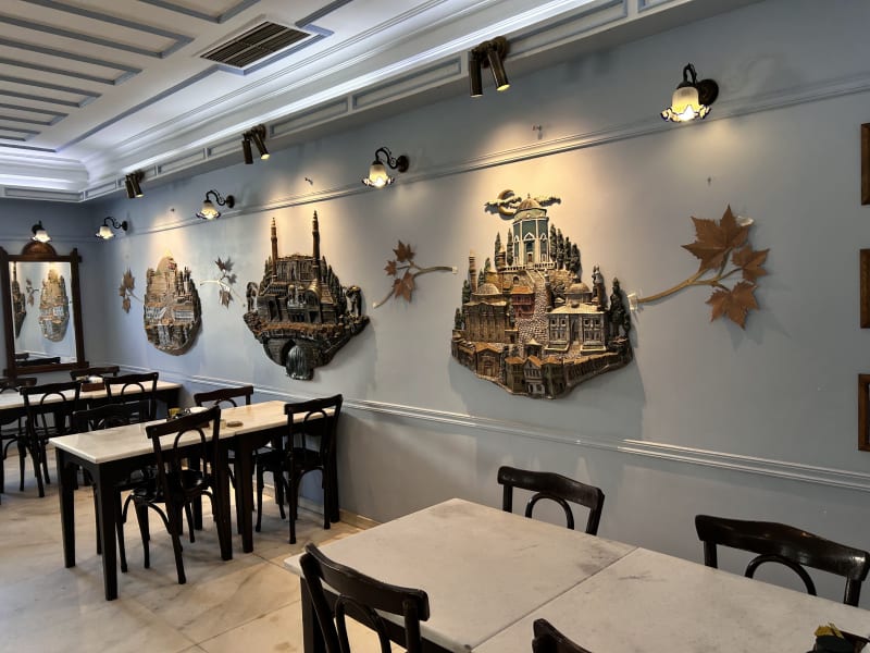 Mavi Dükkan salonu, duvarlarda Bursa temalı süslemeler