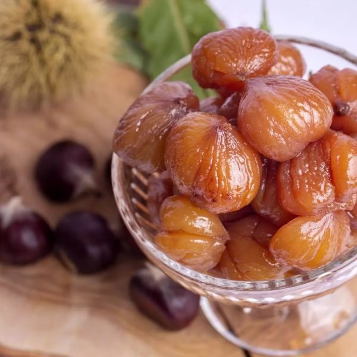 Bursa'nın meşhur Kestane Şekeri tatlısının cam kasede sunumu ve arka planda ham kestaneler.