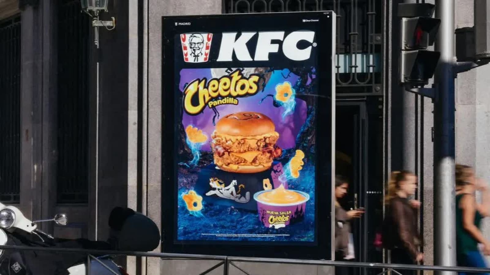 El mismo mupi de KFC y Cheetos Pandilla de día, con la hamburguesa y la salsa a todo color