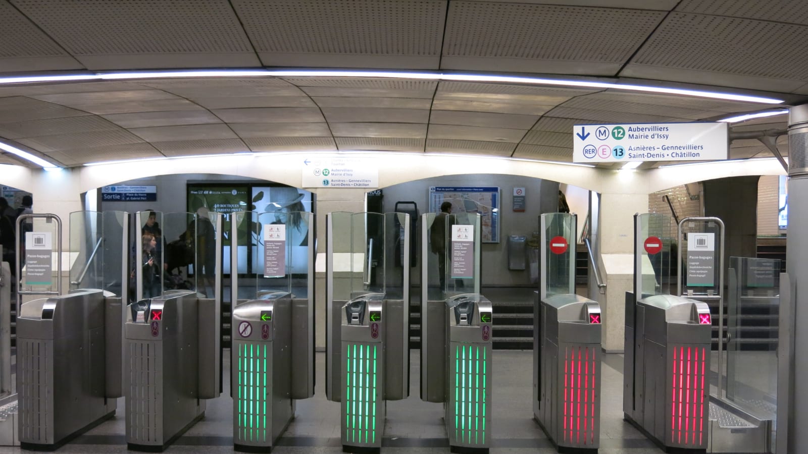 Fila de tornos de acceso en una estación de metro, unos con la luz verde abierta y otros con la luz roja cerrada