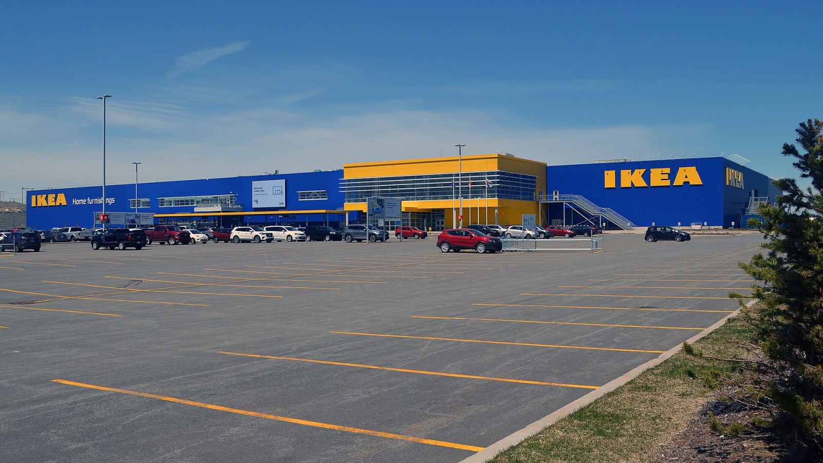Exterior de una tienda IKEA con su fachada azul y amarilla y el aparcamiento delante