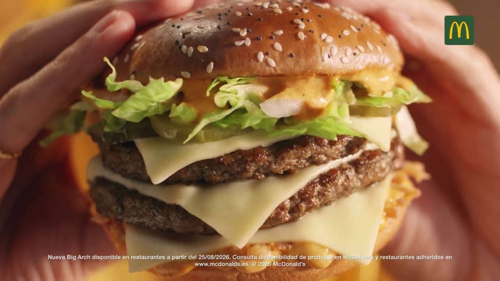 Fotograma del anuncio de McDonald's España con la hamburguesa Big Arch sostenida en las manos