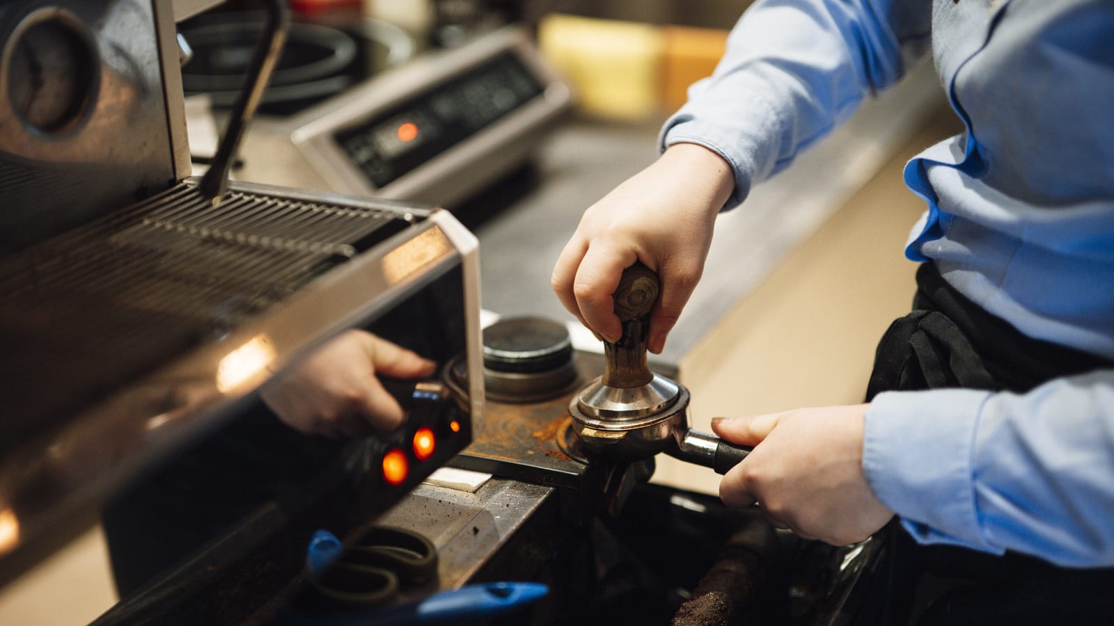 Barista preparando un espresso tras la barra de una cafetería