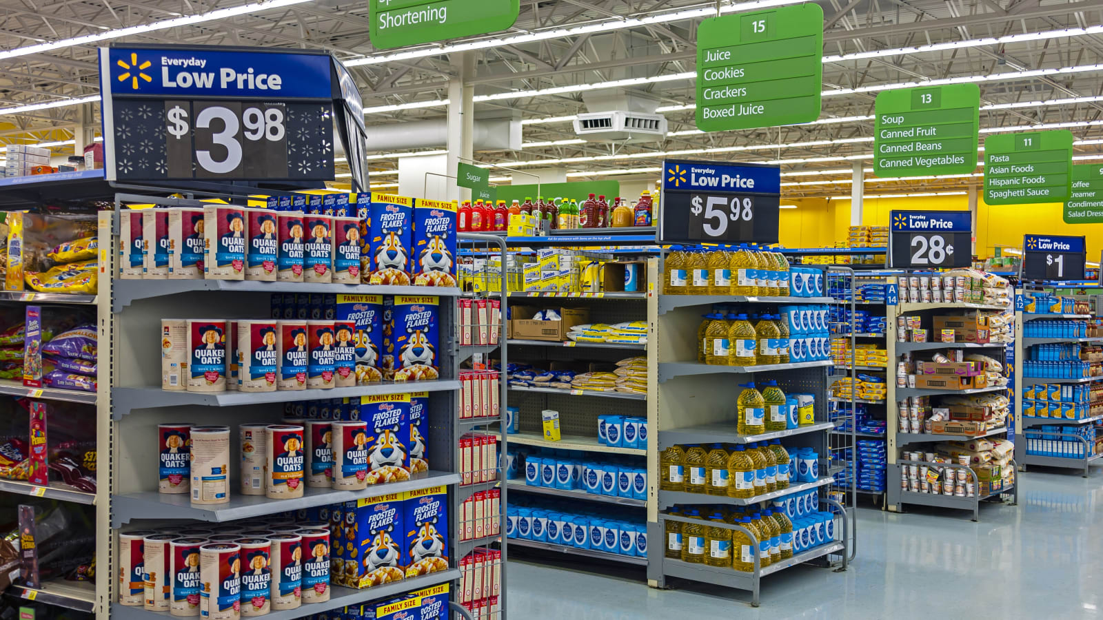 Pasillo de un supermercado Walmart con expositores de cabecera y carteles de precio colgando del techo