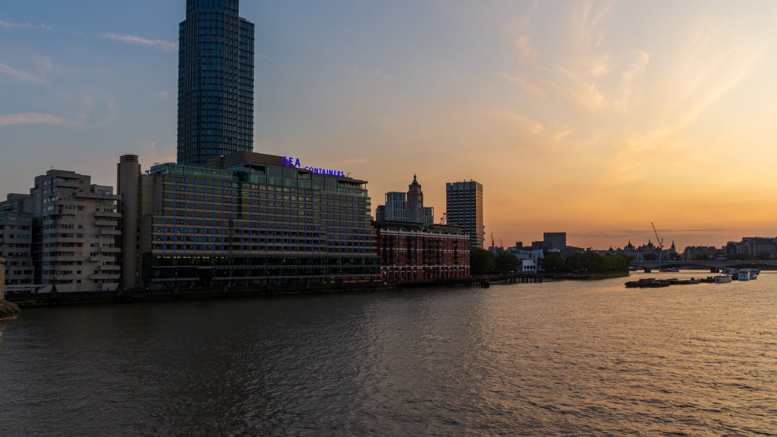 Sea Containers House y la orilla sur del Támesis en Londres al atardecer, con el río en primer plano