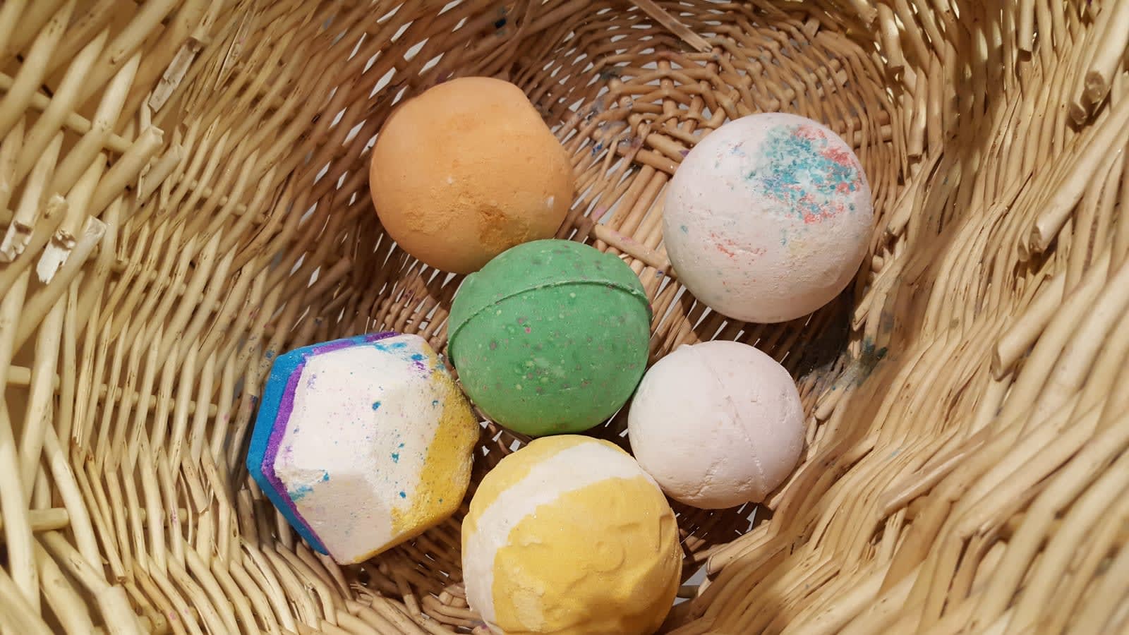 Bombas de baño de colores de Lush en una cesta de mimbre