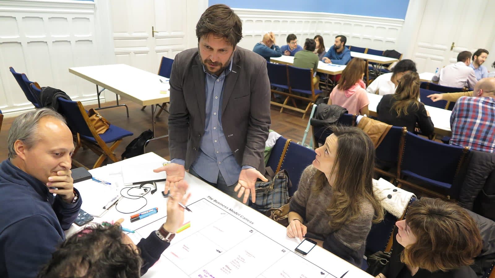 Grupo de personas trabajando sobre un lienzo de Business Model Canvas impreso en un taller en Madrid
