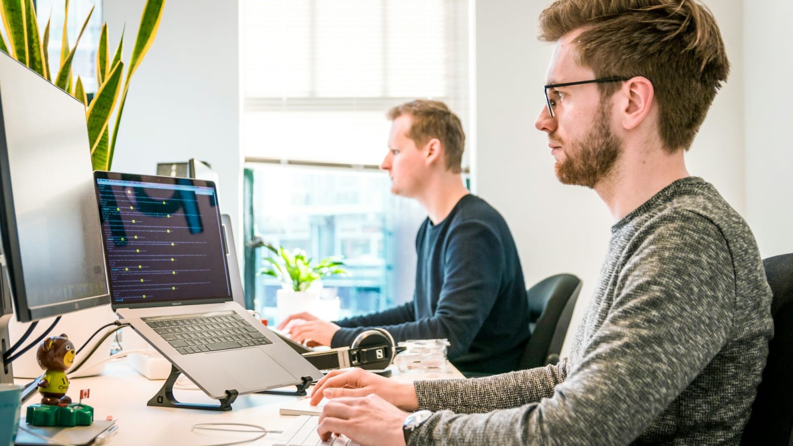 Equipo de desarrollo trabajando en una oficina frente a computadores