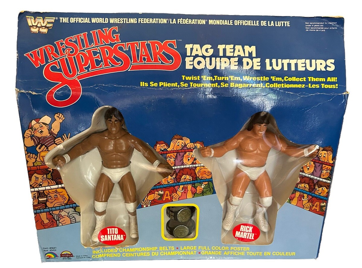 Main front view of 1985 Titan Sports Wrestling Superstars collectible featuring Strike Force Tito Santana and Rick Martel with tag team championship belts, vintage wrestling item showing artwork, belt detail and character names