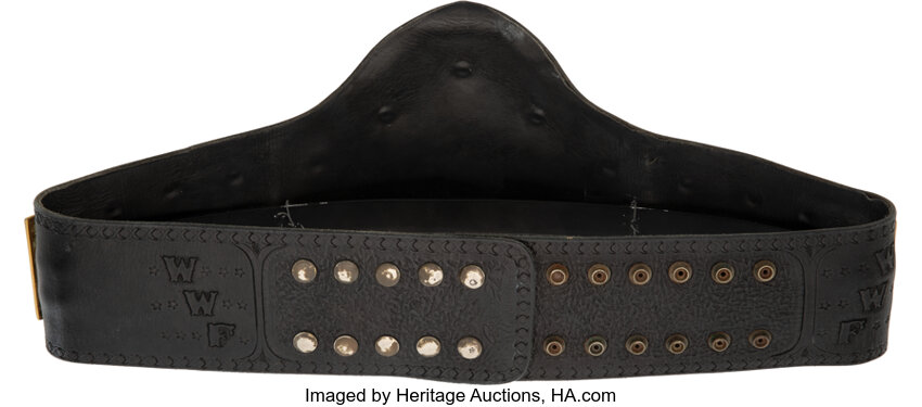 Close up alternate angle of the championship belt center plate and brown leather strap showing wear marks provenance and photo matched evidence linking the belt to Hulk Hogan at WrestleMania II