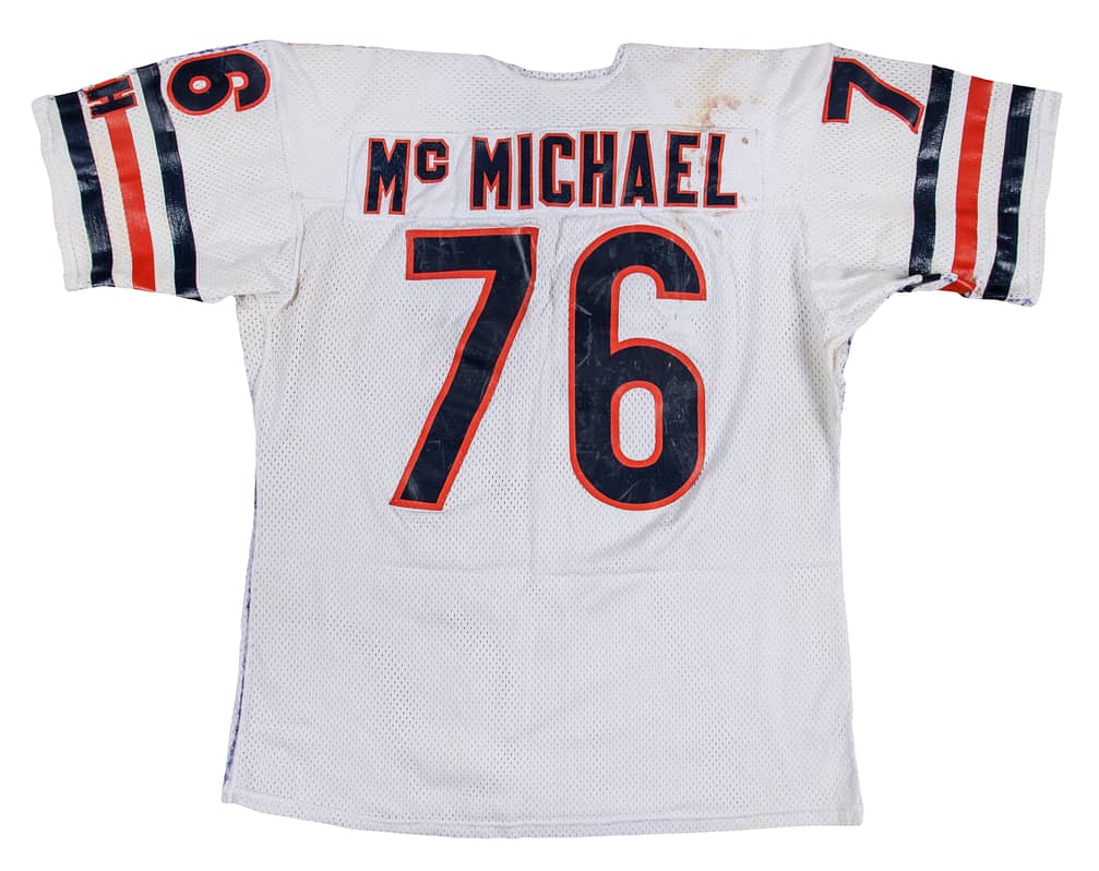 Main front view of 1986 Steve McMichael game-used Chicago Bears jersey photo-matched to Super Bowl XX (January 26, 1986), full front number and Bears orange/navy trim visible with game-use wear, includes McMichael LOA, Resolution Photomatching & Beckett authentication